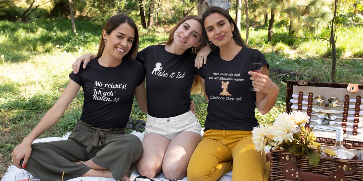 Drei Frauen bei einem Picknick mit T-Shirts mit Pferdemotiven