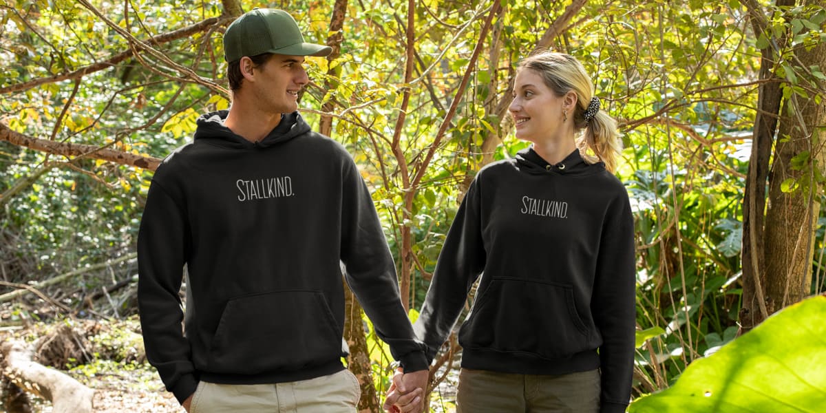 Mann und Frau mit Pferdepullover mit der Aufschrift "Stallkind"